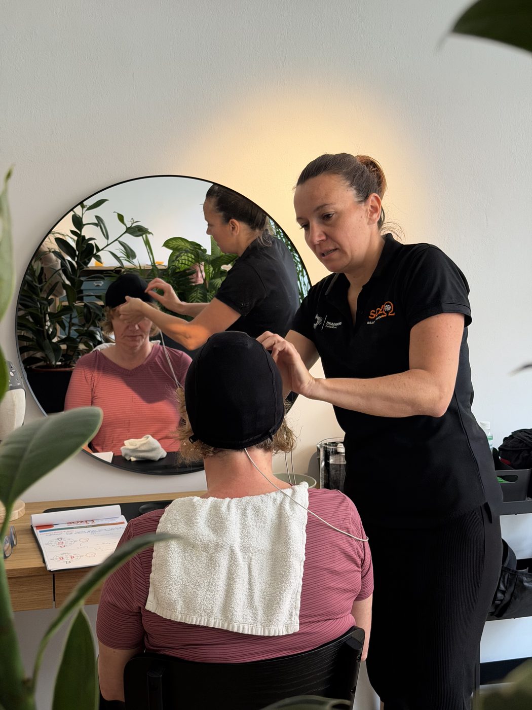 Eine Mitarbeiterin legt die Haube für die tDCS an